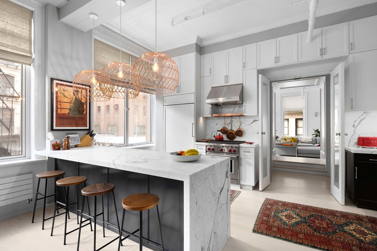 Kitchen island with marble counters and wood stools