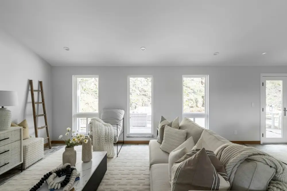 A breathtaking modern home renovation, bathed in warm natural light filtering through large windows. The open-concept layout seamlessly blends the living room, kitchen, and dining area, creating a harmonious and inviting atmosphere. Sleek, minimalist furnishings in earthy tones complement the Renotive brand's elegant, sophisticated design. Strategically placed accent pieces, such as a statement light fixture and a lush indoor plant, add visual interest and a touch of nature. The overall scene exudes a sense of calm, comfort, and inspiration, perfectly capturing the power of visual inspiration in home renovation.